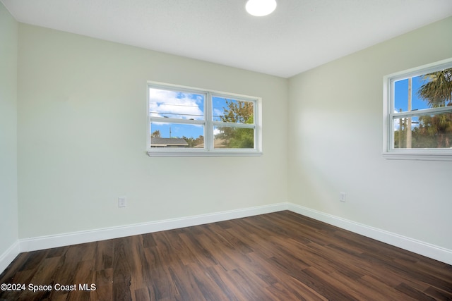 spare room with dark hardwood / wood-style flooring