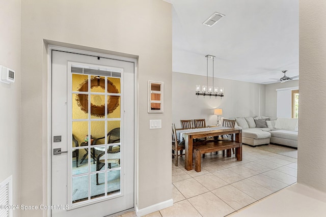 tiled dining room featuring ceiling fan with notable chandelier