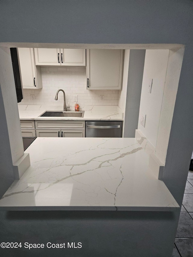 kitchen featuring sink, decorative backsplash, and dishwasher