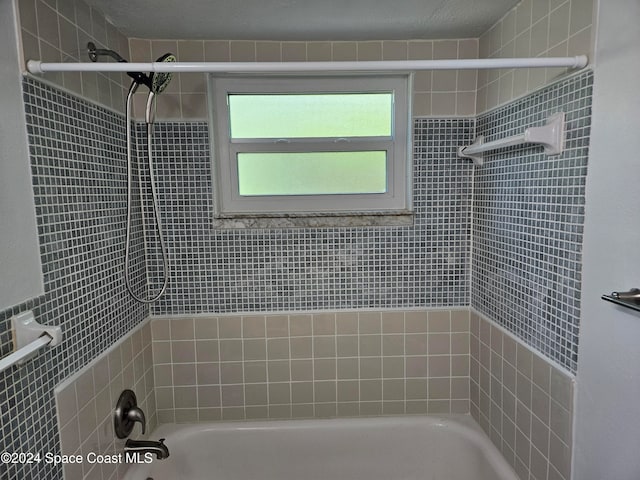 bathroom featuring tiled shower / bath