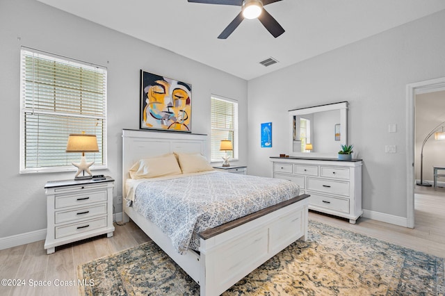 bedroom with light hardwood / wood-style flooring, multiple windows, and ceiling fan