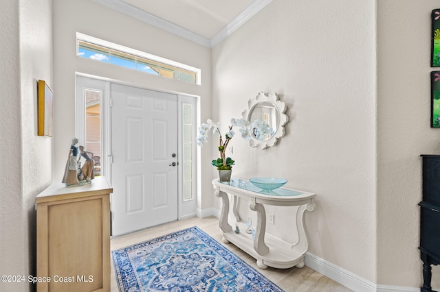 foyer entrance featuring light hardwood / wood-style floors and crown molding