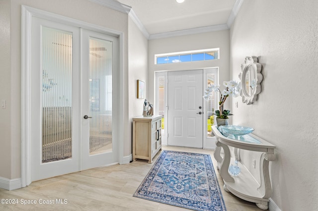 foyer entrance featuring french doors, light hardwood / wood-style floors, crown molding, and plenty of natural light