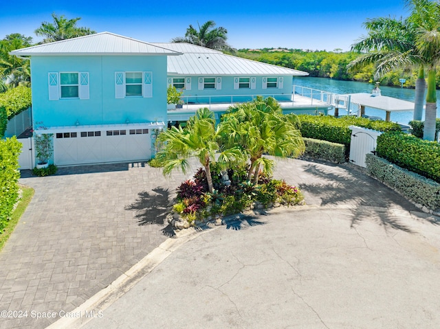 view of front of house with a garage and a water view