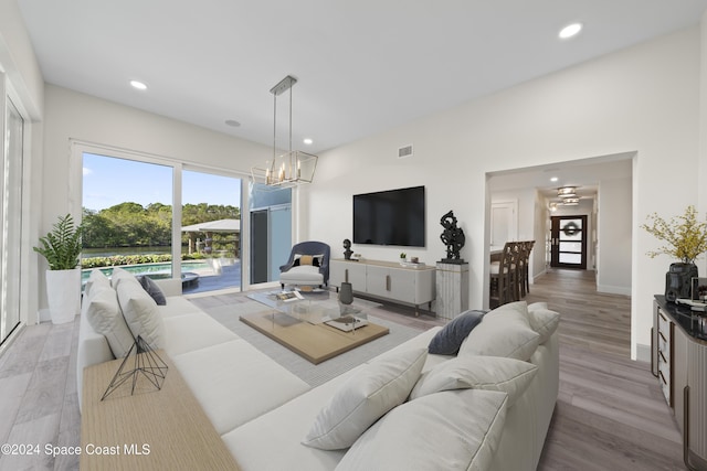 living room featuring light hardwood / wood-style flooring and a notable chandelier