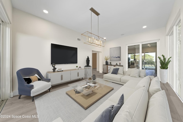 living room featuring light wood-type flooring and a chandelier