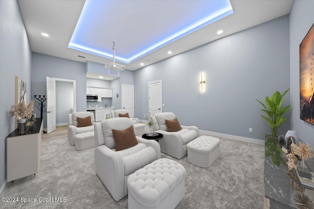 cinema featuring light colored carpet and a raised ceiling