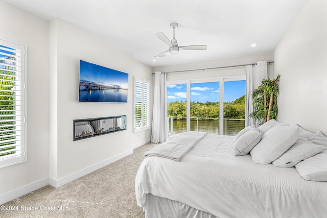 bedroom featuring multiple windows, light carpet, and ceiling fan