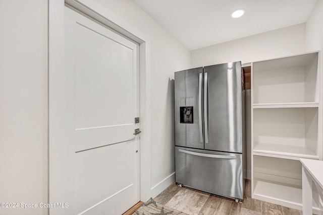 kitchen with light hardwood / wood-style flooring and stainless steel refrigerator with ice dispenser