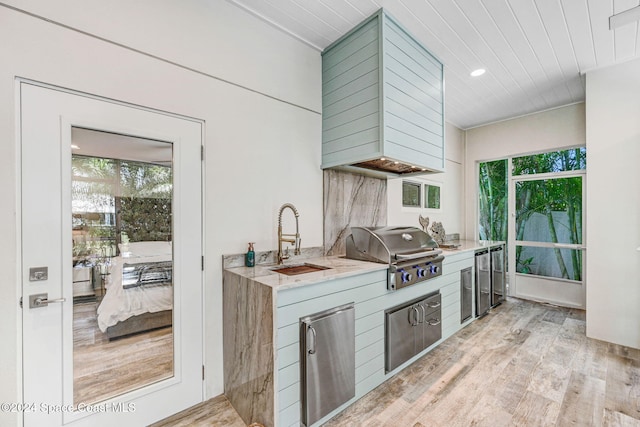 kitchen with stainless steel fridge, light wood-type flooring, and sink