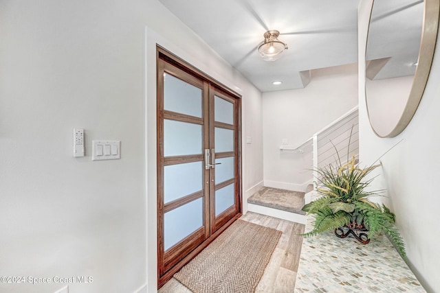 foyer featuring light wood-type flooring and french doors