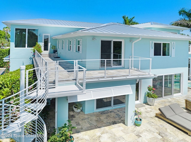 back of property featuring a patio and a balcony