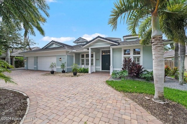 view of front of home with a garage, decorative driveway, and stucco siding