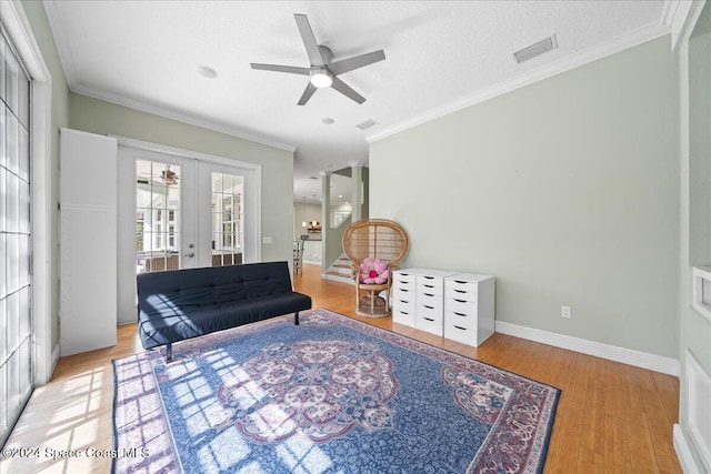 sitting room featuring ceiling fan, light hardwood / wood-style floors, crown molding, and french doors