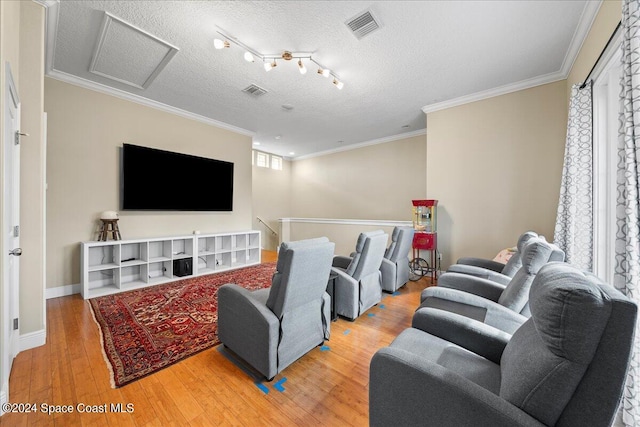 home theater with crown molding, wood-type flooring, and a textured ceiling