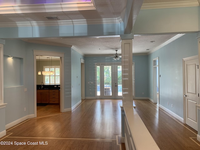 unfurnished living room with french doors, ceiling fan, crown molding, sink, and hardwood / wood-style floors