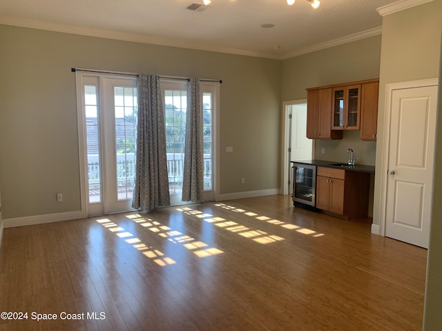 kitchen featuring sink, dark hardwood / wood-style flooring, crown molding, and wine cooler