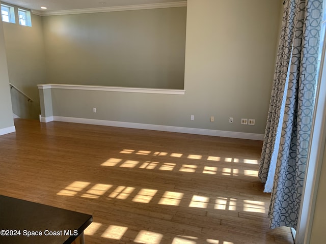 empty room with hardwood / wood-style floors and ornamental molding