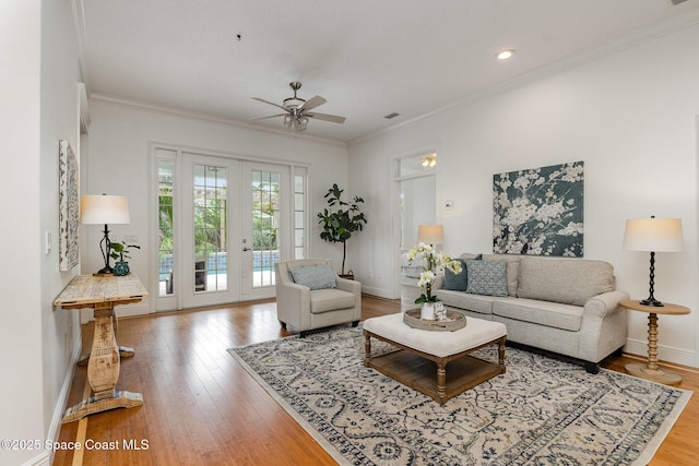 living area with ornamental molding, french doors, baseboards, and wood finished floors