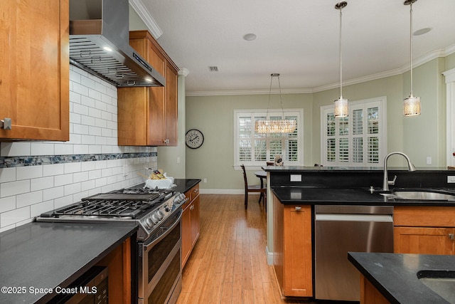 kitchen with stainless steel appliances, hanging light fixtures, exhaust hood, and brown cabinets