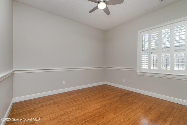 unfurnished room with ceiling fan, baseboards, and wood finished floors