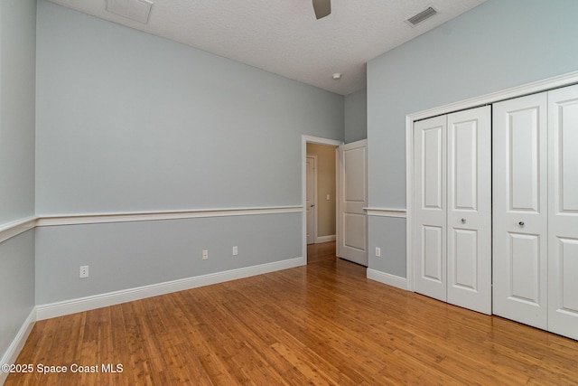 unfurnished bedroom featuring light wood-style floors, a closet, and visible vents