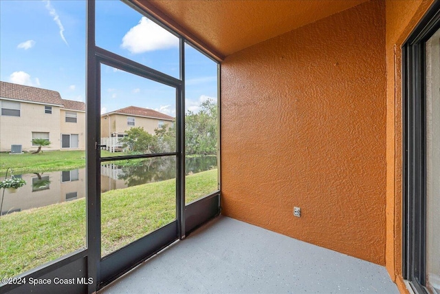 unfurnished sunroom featuring a water view