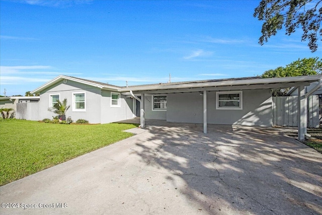 1500 Dorsal St, Merritt Island, FL 32952 - view of front of home with stucco siding, a carport, a front lawn, and driveway