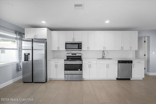 1500 Dorsal St, Merritt Island, FL 32952 - kitchen with appliances with stainless steel finishes, a sink, baseboards, white cabinets, and recessed lighting