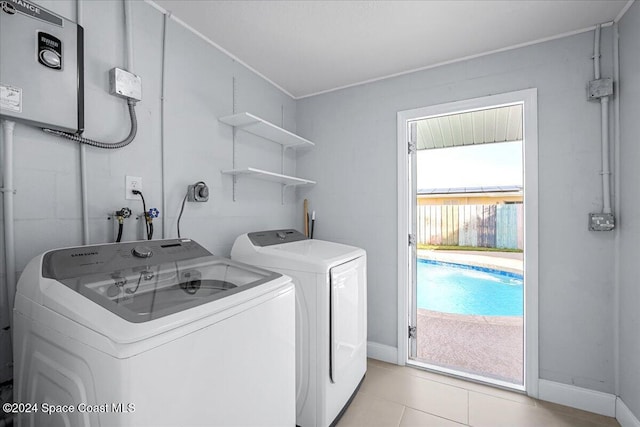 clothes washing area with a wealth of natural light, washing machine and dryer, and light tile patterned floors