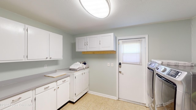 laundry area with independent washer and dryer and cabinets