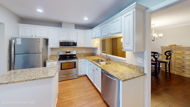 kitchen featuring light hardwood / wood-style flooring, appliances with stainless steel finishes, sink, and white cabinets