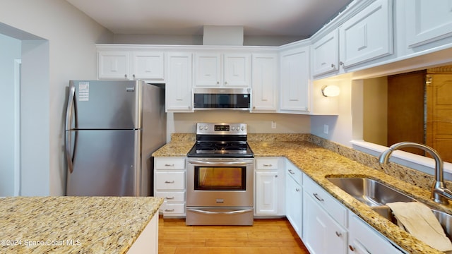 kitchen featuring sink, appliances with stainless steel finishes, white cabinetry, and light hardwood / wood-style floors