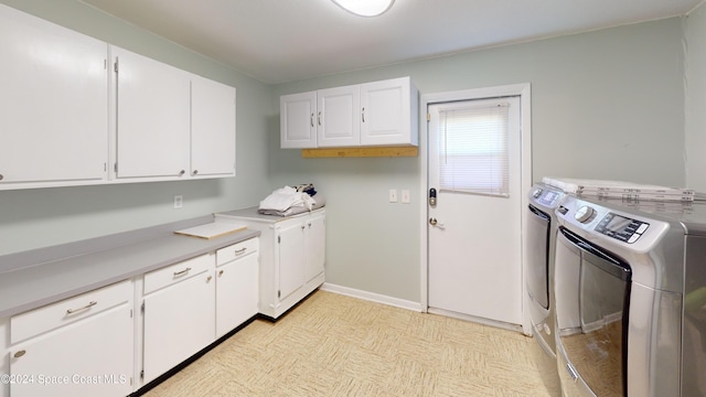 clothes washing area with cabinets and separate washer and dryer