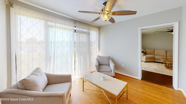 living area with hardwood / wood-style floors and ceiling fan