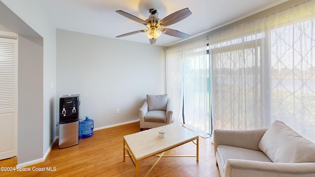 living area featuring hardwood / wood-style floors and ceiling fan