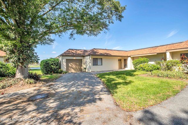 view of front of home with a front yard and a garage