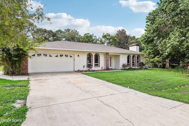 single story home featuring a front lawn, a garage, concrete driveway, a chimney, and stucco siding
