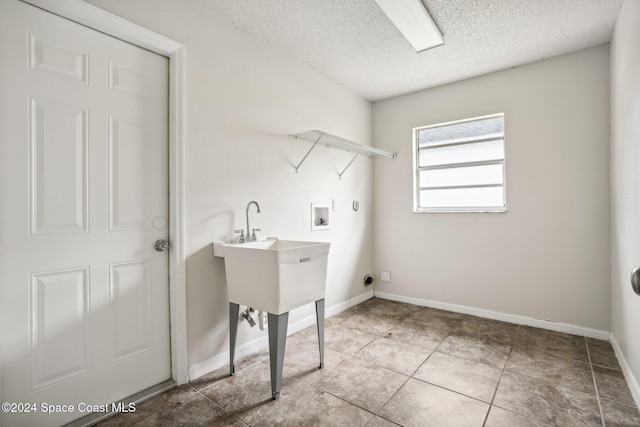 laundry area with hookup for a washing machine, a textured ceiling, tile patterned floors, hookup for an electric dryer, and hookup for a gas dryer