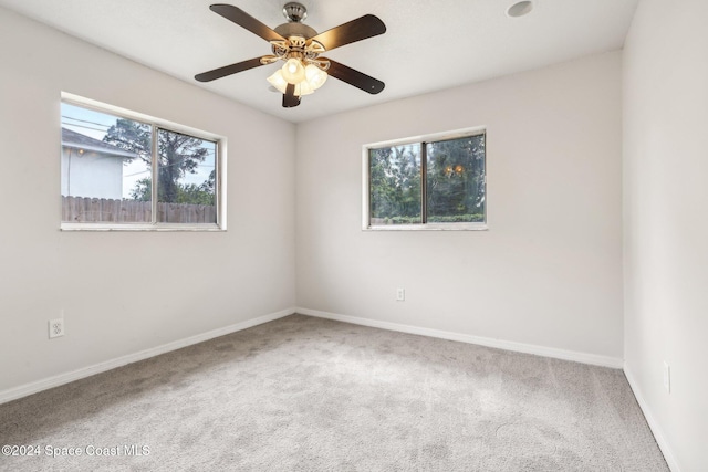 spare room with carpet, ceiling fan, and a wealth of natural light