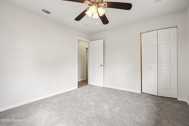 unfurnished bedroom with carpet, a closet, and ceiling fan