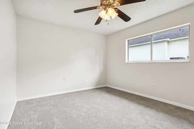 carpeted empty room featuring ceiling fan and a textured ceiling