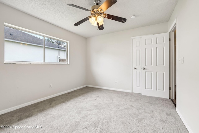 unfurnished bedroom with carpet flooring, a textured ceiling, and ceiling fan