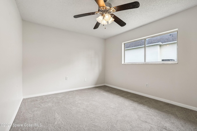 carpeted spare room with a ceiling fan and baseboards