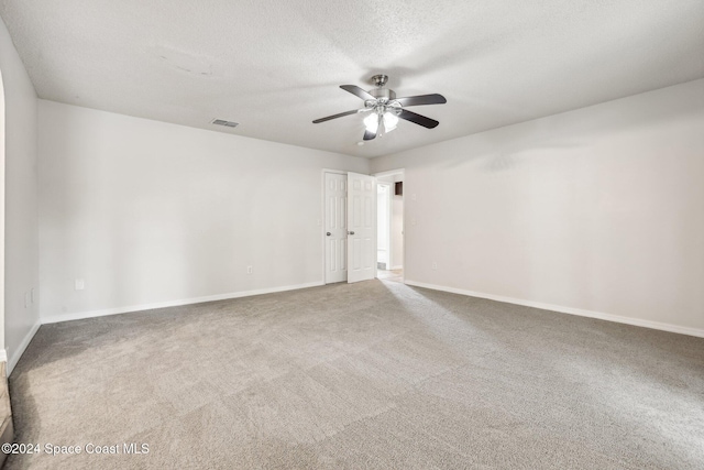empty room with a ceiling fan, carpet, baseboards, and a textured ceiling