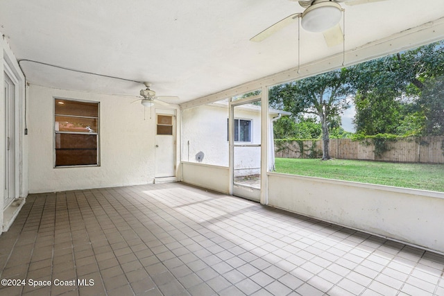 unfurnished sunroom with a ceiling fan and healthy amount of natural light