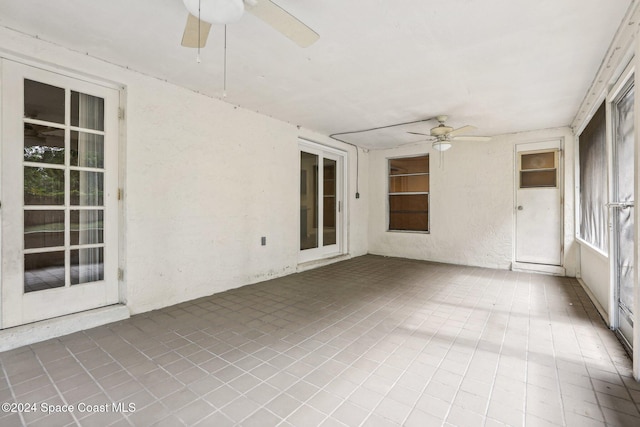 unfurnished sunroom featuring ceiling fan