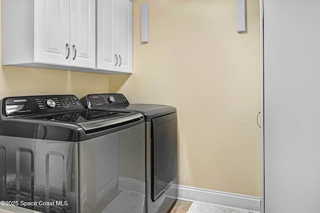 washroom with cabinets, tile patterned flooring, and washer and clothes dryer