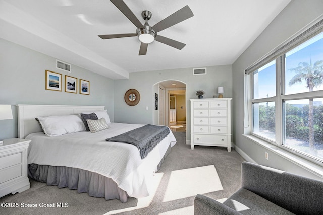 bedroom featuring carpet flooring, multiple windows, ensuite bathroom, and ceiling fan