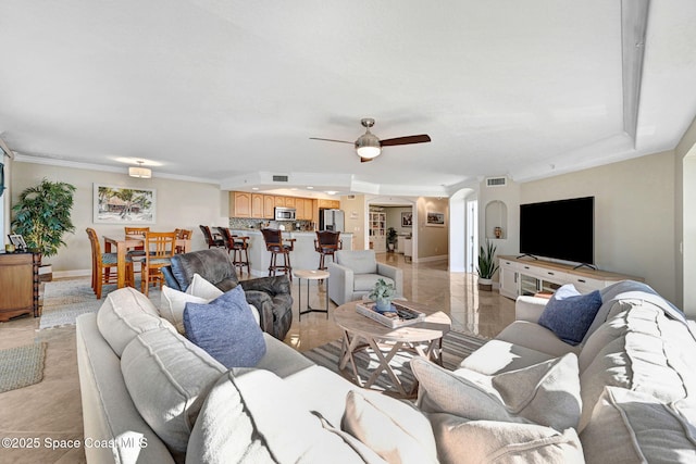 living room with ceiling fan and crown molding